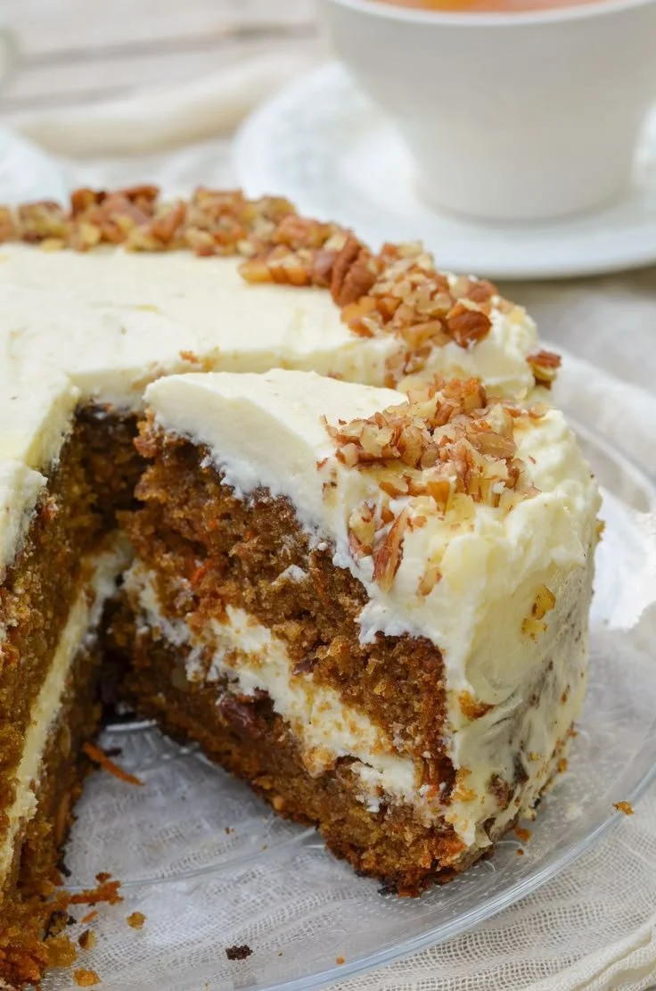 Une délicieuse part de carrot cake au cream cheese sur une assiette.