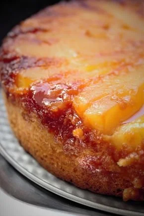 Slice of Gâteau Tatin Poire topped with caramel, almonds, and spices on a plate.