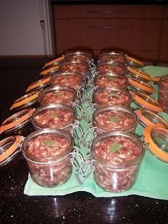Homemade pâté de base served on a wooden board with herbs and crackers.