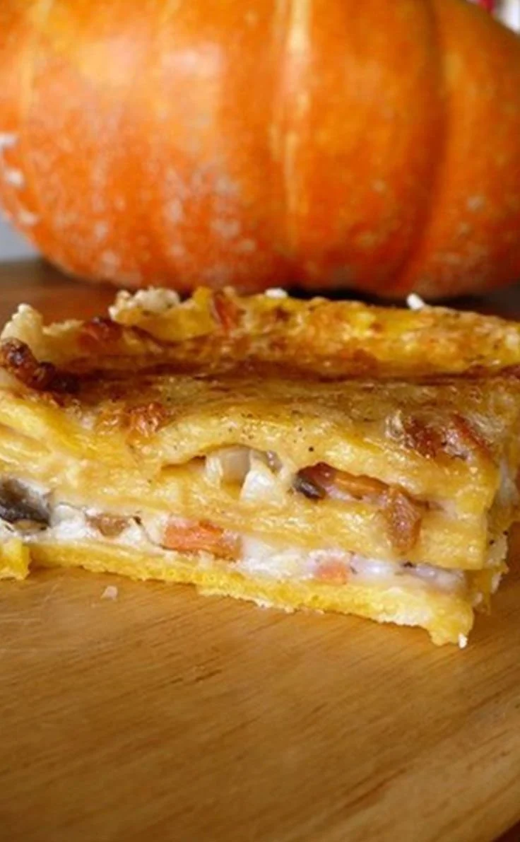 Plat de lasagnes de citrouille aux champignons sur une table garnie.