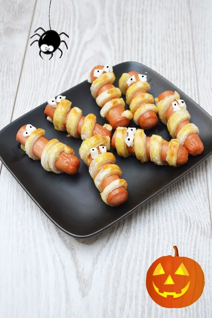 Saucisses momies d'Halloween servies sur une assiette décorée.